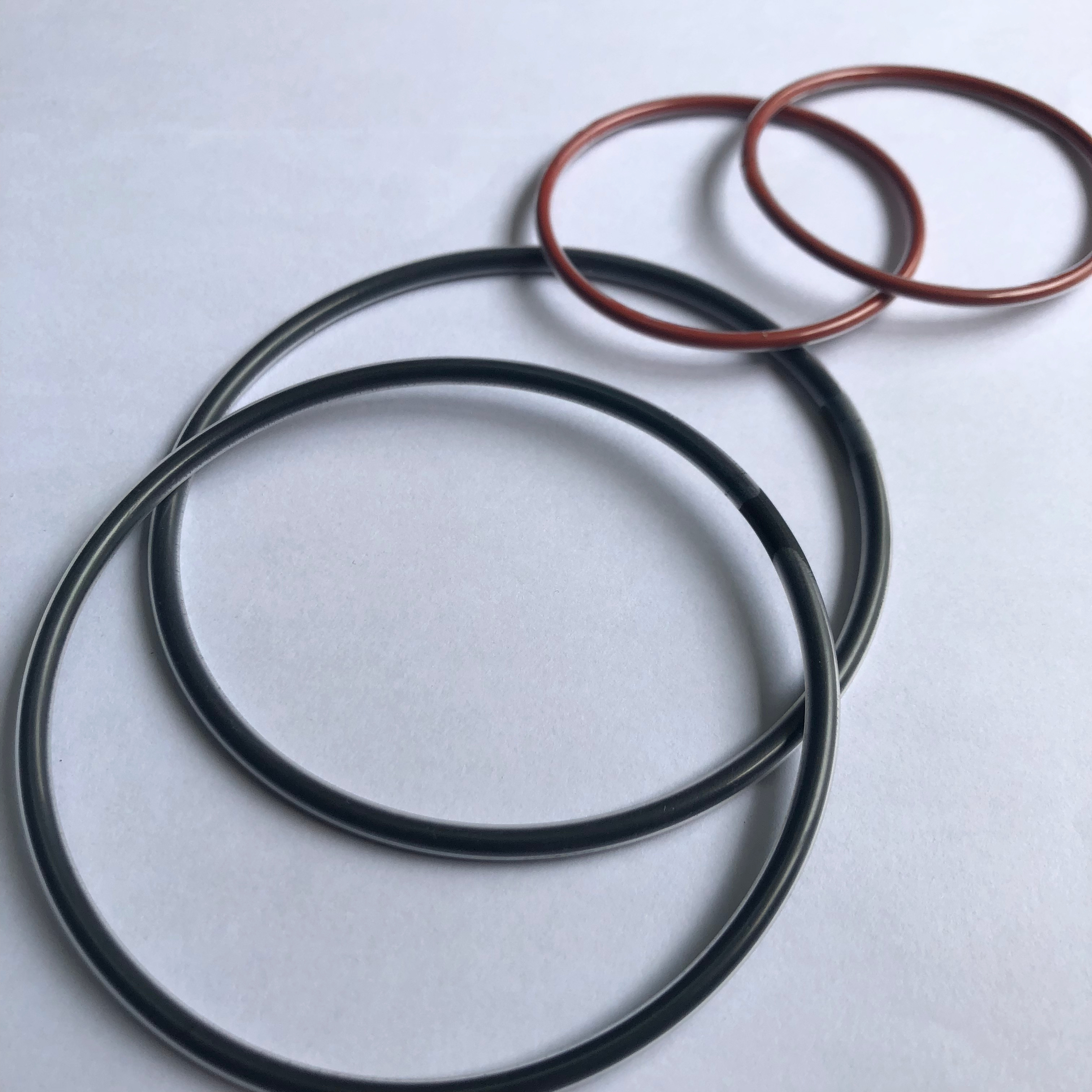 Black and red-brown O-rings arranged in overlapping pairs